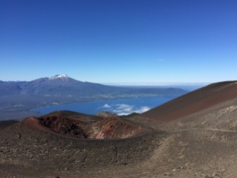 A red scoria crater with Calbuco and the lake behind.